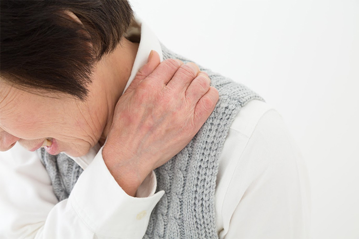 左肩をおさえている女性